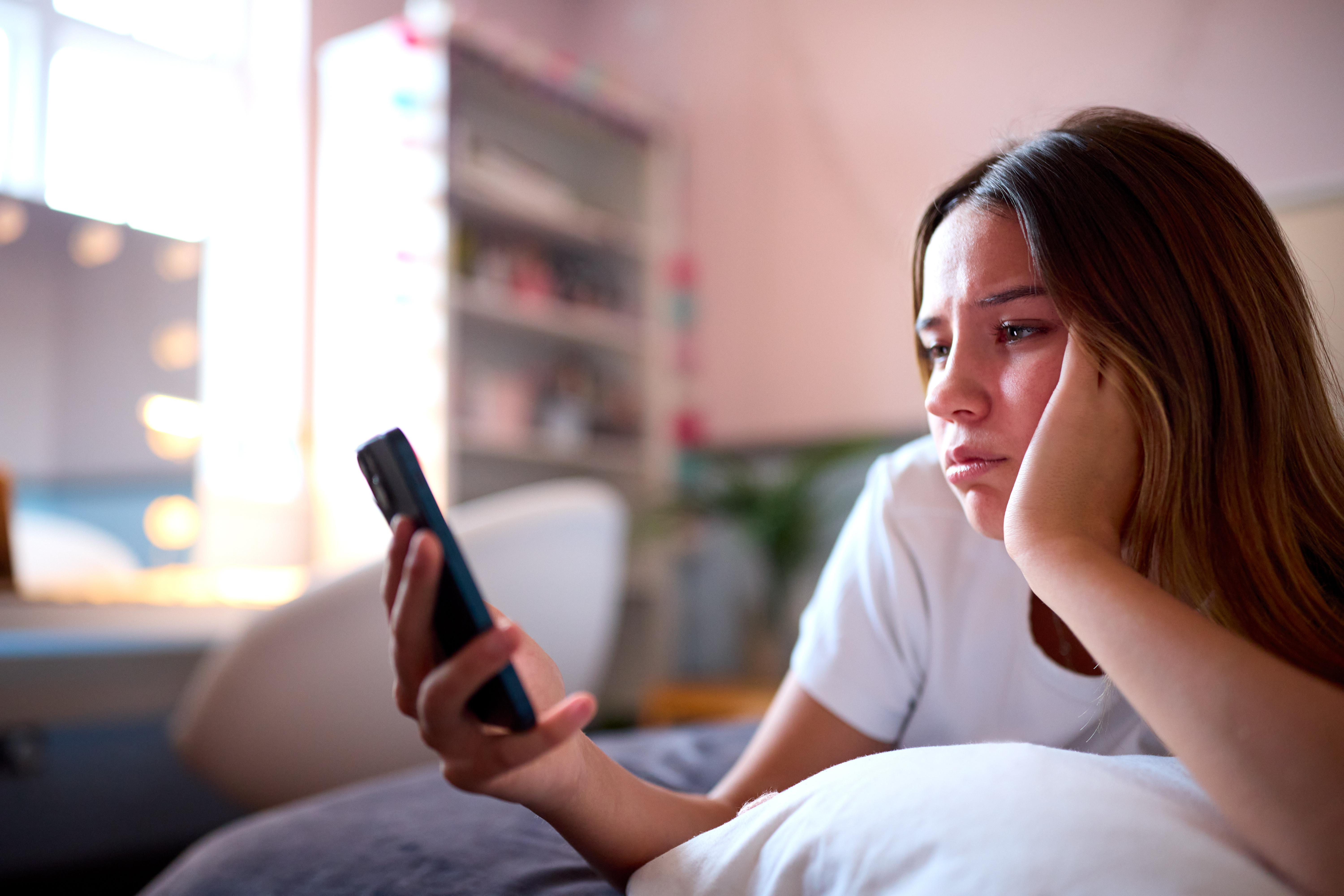 image of teen sad with cellphone